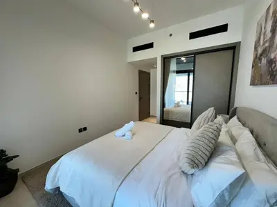 a bedroom with a large white bed with pillows at Stylish 1br Apartment Jvc Balcony Parking in Dubai