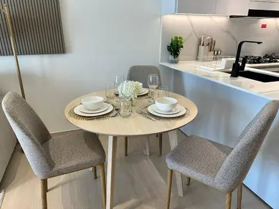 a table in a kitchen with chairs and plates and glasses at Stylish 1br Apartment Jvc Balcony Parking in Dubai