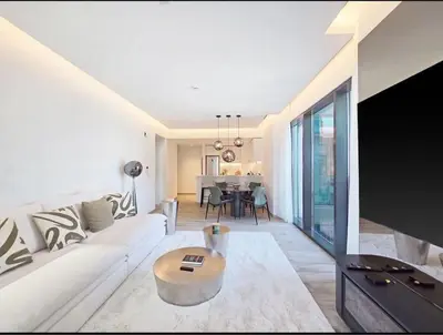 a living room with a white couch and a table at FIRST CLASS 1BR Charming City in Dubai