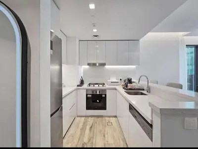 a white kitchen with a sink and a stove at FIRST CLASS 1BR Charming City in Dubai