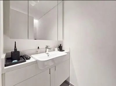 a white bathroom with a sink and a mirror at FIRST CLASS 1BR Charming City in Dubai
