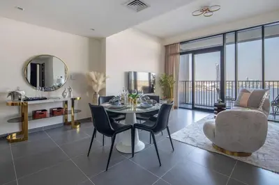 a living room with a table and chairs and a mirror at Frank Porter - Creek Edge Tower 1 in Dubai