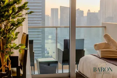 a balcony with a bed and a view of a city at The Charming in Dubai