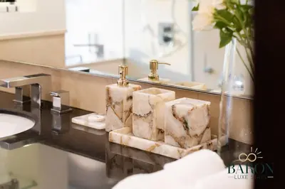 a bathroom with a sink and a mirror and towels at The Charming in Dubai