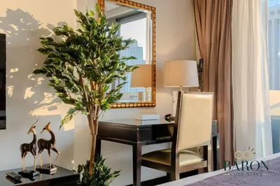 a bedroom with a desk and a chair and a mirror at The Charming in Dubai