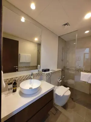 a bathroom with a sink and a toilet and a mirror at Cozy 2BR Apartment DAMAC VERA Business Bay in Dubai