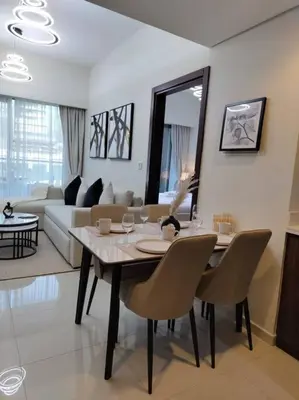 a dining table and chairs in a living room at Cozy 2BR Apartment DAMAC VERA Business Bay in Dubai