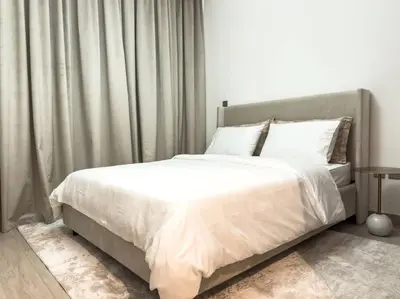 a bedroom with a large bed with white sheets at Newly Furnished Studio Azizi Riviera 37 Al Meydan in Dubai