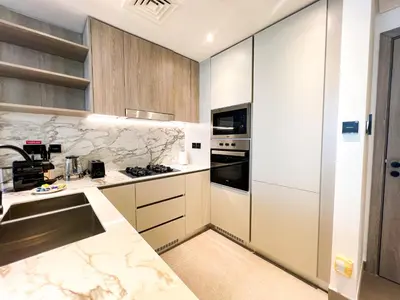 a kitchen with white cabinets and a counter top at 1-BR Gem with Luxe Amenities in JVC in Dubai