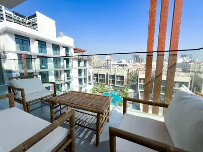 a balcony with a table and chairs and a view at 1-BR Gem with Luxe Amenities in JVC in Dubai