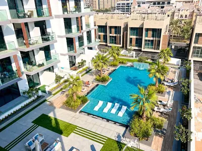 an overhead view of an apartment complex with a swimming pool at 1-BR Gem with Luxe Amenities in JVC in Dubai