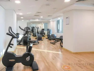 a gym with several treadmills and exercise bikes at Luxury Canal View Studio at Sparkle Tower in Dubai