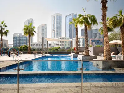 a swimming pool with a city skyline in the background at Luxury Canal View Studio at Sparkle Tower in Dubai