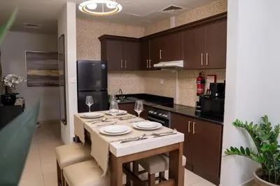 a kitchen with a table with plates and wine glasses at Skyline Dream - 1 BHK - Burj and Canal views in Dubai