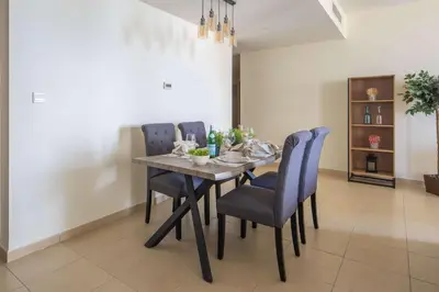 a dining room with a table and blue chairs at Frank Porter - Murjan 1 in Dubai