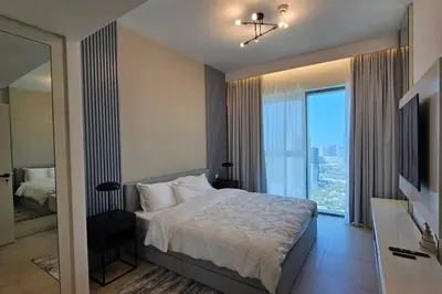 a bedroom with a bed and a large window at Downtown Dubai views 2 tower 1 in Dubai