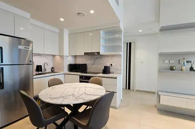 a kitchen with a table and chairs and a refrigerator at Downtown Dubai views 2 tower 1 in Dubai