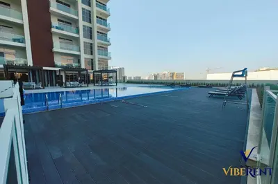 a large swimming pool on the side of a building at Stylish and Cozy Studio Apartment in Dubai