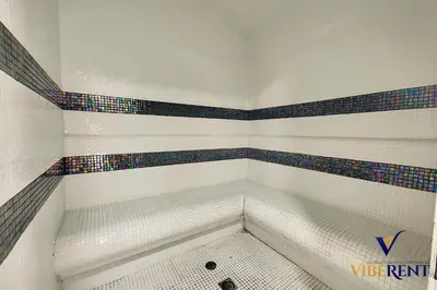 a bathroom with a tub with colorful tiles at Stylish and Cozy Studio Apartment in Dubai