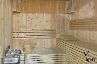 a sauna with a tub and a bucket and logs at Stylish and Cozy Studio Apartment in Dubai