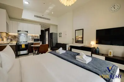 a large bedroom with a large bed and a kitchen at Stylish and Cozy Studio Apartment in Dubai