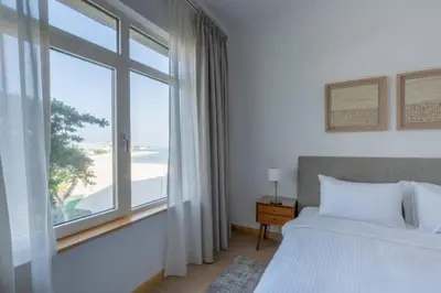 a bedroom with a bed and a large window at Elegant 1BR beach access with Ocean Views, Palm in Dubai