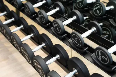a row of dumbbells in a gym at Sleek & Spacious 1br Jvc Pool View in Dubai