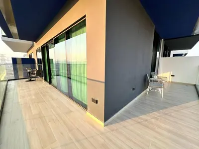 an empty room with chairs and windows on a building at Sleek & Spacious 1br Jvc Pool View in Dubai