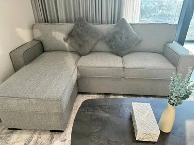 a living room with a couch and a coffee table at Sleek & Spacious 1br Jvc Pool View in Dubai