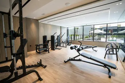 a gym with several treadmills and exercise bikes at Sleek & Spacious 1br Jvc Pool View in Dubai