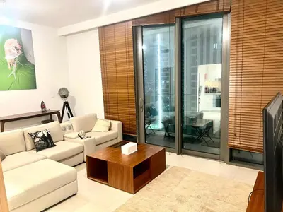 a living room with a couch and a coffee table at Downtown views-access to Dubai Mall! in Dubai