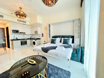a bedroom with a king sized bed and a kitchen at Modern Studio in Business Bay in Dubai