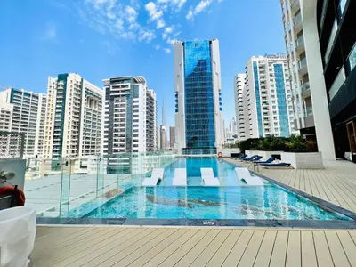 a swimming pool in a city with tall buildings at Modern Studio in Business Bay in Dubai
