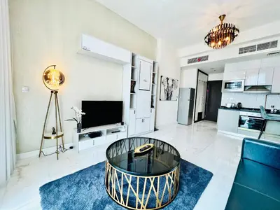 a living room with a table and a tv at Modern Studio in Business Bay in Dubai