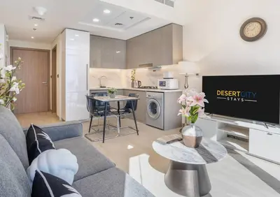 a living room with a couch and a kitchen at Fully Furnished One Bed in Meydan, Hosted by Desert City Stays in Dubai