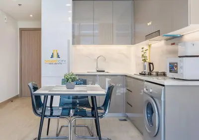 a kitchen with a table and a washing machine at Fully Furnished One Bed in Meydan, Hosted by Desert City Stays in Dubai