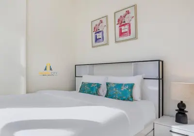 a white bedroom with a white bed with two pillows at Fully Furnished One Bed in Meydan, Hosted by Desert City Stays in Dubai