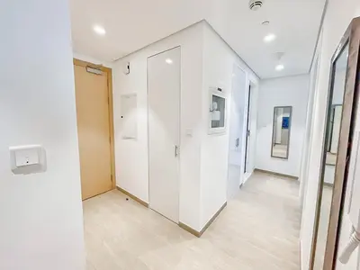 an empty hallway with white walls and wood floors at Luxury 2 Bedroom in the Nook 1 next to Metro Energy in Dubai