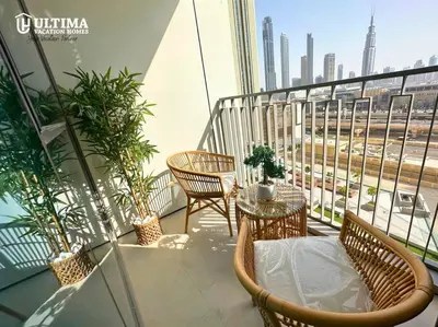 a balcony with chairs and tables and a view of a city at Elegant 2BR Burj Khalifa view-Downtown Views II in Dubai