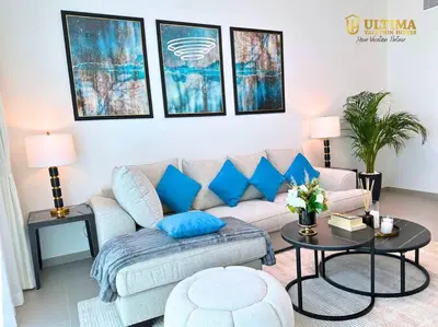 a living room with a couch and blue pillows at Elegant 2BR Burj Khalifa view-Downtown Views II in Dubai