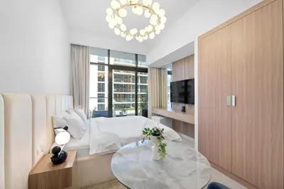 a living room with a glass table and a chandelier at Studio Azizi Riviera 28 Community View in Dubai