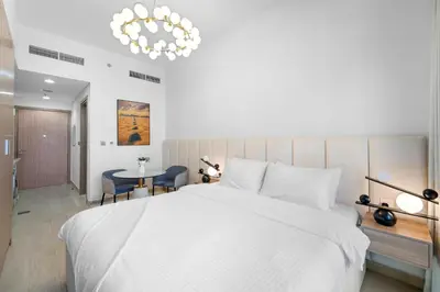 a bedroom with a large white bed and a table at Studio Azizi Riviera 28 Community View in Dubai