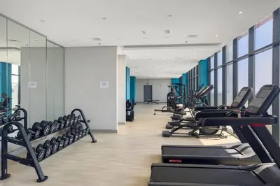 a gym with a row of treadmills and machines at Studio Azizi Riviera 28 Community View in Dubai