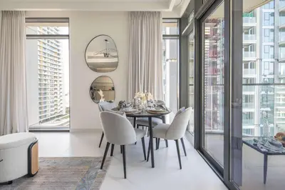 a dining room with a table and chairs and windows at Frank Porter - Marina Vista tower 2 in Dubai