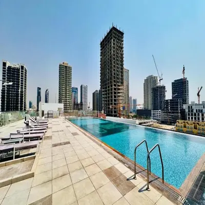 a large swimming pool on top of a city skyline at Premium 1-Bedroom Perla Apartment in JVC | Infinity Pool & Kids’ Play Area in Abu Dhabi