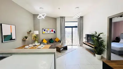a living room with a couch and a table at Premium 1-Bedroom Perla Apartment in JVC | Infinity Pool & Kids’ Play Area in Abu Dhabi