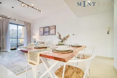 a white dining room with a table and chairs at Bahar, Jumeirah Beach Residence JBR - Mint Stay in Dubai