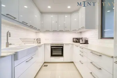 a white kitchen with white cabinets and a sink at Bahar, Jumeirah Beach Residence JBR - Mint Stay in Dubai