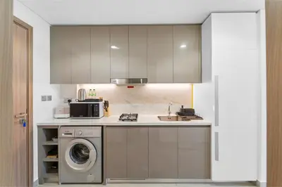 a kitchen with a sink and a washing machine at Studio Azizi Riviera 24 Community View in Dubai