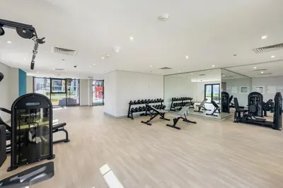 a gym with treadmills and ellipticals in a building at Studio Azizi Riviera 24 Community View in Dubai